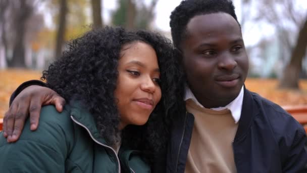 Молодой Человек Женщина Обнимаются Сидя Скамейке Осеннем Парке Разговаривают Целуясь — стоковое видео