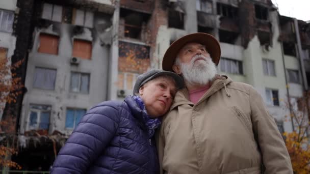Panowanie Wokół Zdewastowanej Ukraińskiej Pary Seniorów Stojącej Zewnątrz Zbombardowanym Zrujnowanym — Wideo stockowe