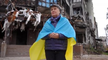 Bombalanan sivil evin arkasında duran Ukrayna bayrağıyla yıkılmış yaşlı kadına yakınlaş. Hüsrana uğramış, umutsuz emekliler, başka yöne bakıp düşünüyorlar. Yavaş çekim