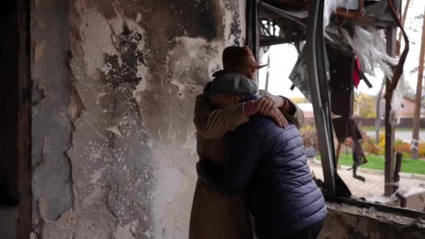 拥抱站在被摧毁的战争摧毁的高级悲伤夫妇的建筑思维 在被轰炸的乌克兰城市 绝望绝望的男人和女人在被毁房屋中的画像 — 图库视频影像
