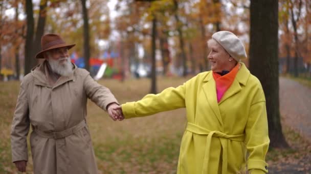Fröhliche Seniorin Der Hand Eines Mannes Der Lächelnd Die Herbstliche — Stockvideo