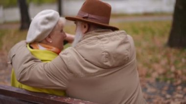 Arkaya bakan, yaşlı kocayı seven, karısına sarılan, eşiyle birlikte sonbahar parkında bankta oturan. Kafkasyalı mutlu bir çiftin omzunun üstünden ateş ederek dışarıda dinlenmenin keyfini çıkarıyorlar.