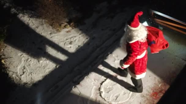 尽收眼底圣诞老人在门廊下挥手道别 在雪地的后院离去 除夕户外身穿红色服装的自信白人男子的高角镜 — 图库视频影像