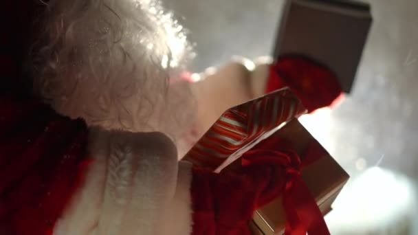 Nahaufnahme Von Weihnachtsgeschenken Den Händen Eines Unkenntlichen Weihnachtsmannes Bei Gegenlicht — Stockvideo