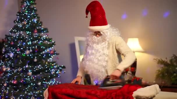Confident Caucasian Man Ironing Red Santa Fur Coat Indoors Living — Stock Video