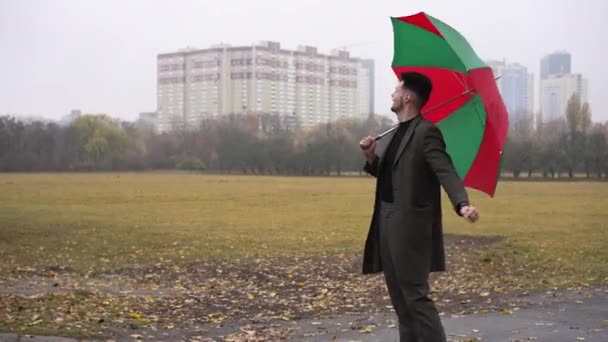 Beau Jeune Homme Debout Avec Parapluie Vert Rouge Par Temps — Video