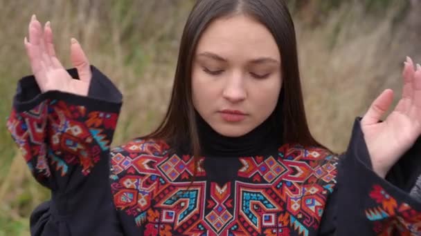 前视迷人的年轻女子 手握着眼睛慢慢地触摸着脸 穿着传统服饰 户外绣花的乌克兰美女的画像 — 图库视频影像