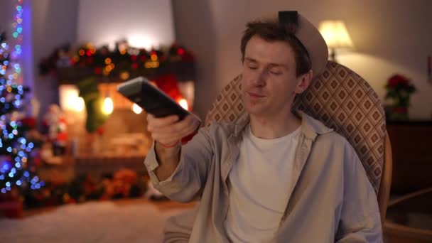 Magányos Lmbt Férfi Csatornát Vált Távirányítóval Aki Karácsony Este Hintaszékben — Stock videók