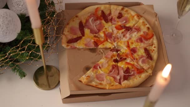 圣诞餐桌上的顶级披萨 白人男性的手拿着切片离开 难以辨认的年轻人在家里吃垃圾食品庆祝新年 — 图库视频影像