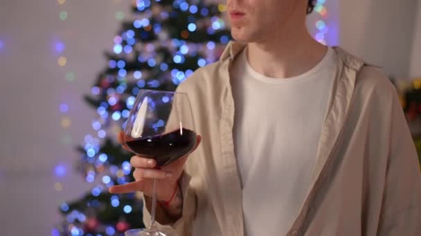 Tânărul Caucazian Nerecunoscut Degustând Vin Roşu Stând Sufragerie Pomul Crăciun — Videoclip de stoc