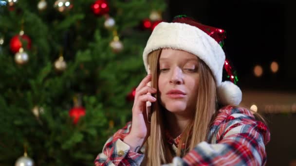 백인젊은 전화로 이야기하는 크리스마스 이브에 아름다운 아가씨 거실에 있어요 — 비디오