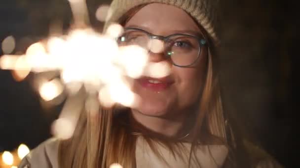 Close Charming Young Woman Eyeglasses Hat Looking Camera Christmas Sparkler — Stock Video