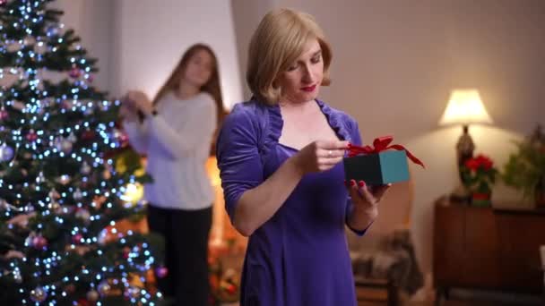 Arka Planda Bulanık Bir Arkadaş Olarak Noel Hediyesiyle Ayakta Duran — Stok video