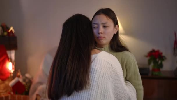 Portrait Hesitating Hypocritical Asian Woman Hugging Friend Trying Smile Christmas — Stock Video