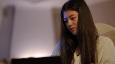Bilgisayarda internette sörf yapan zeki Asyalı kadın portresi içeride otururken düşünüyor. Akıllı kendine güvenen konsantre girişimci planlama işi evdeki e-pazarı analiz ediyor