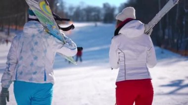 Geriye dönüp baktığımızda, kar kayağı ve snowboard ile kar yamacında yürüyen iki mutlu genç kadın kışın konuşan, açık havada tatil yapan Kafkas 'lı genç bayanların görüntülerini izliyorlar.