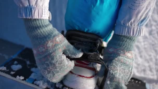 Stopa Bliska Butach Żeńskimi Rękami Mocującymi Snowboard Nierozpoznawalna Kobieta Rękawiczkach — Wideo stockowe