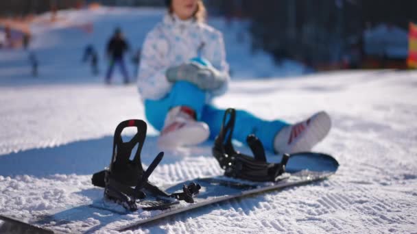 Snowboard Primer Plano Con Una Joven Borrosa Con Dolor Pierna — Vídeo de stock