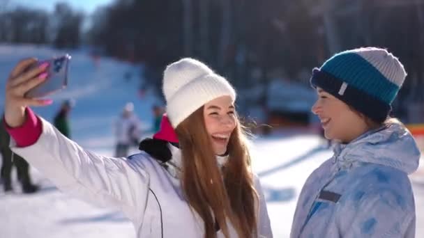 Δύο Ικανοποιημένες Ευτυχισμένες Γυναίκες Blogging Στέκεται Στο Ηλιόλουστο Χειμερινό Θέρετρο — Αρχείο Βίντεο
