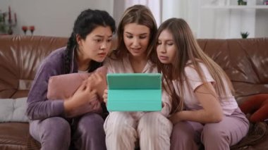 Genç ve güzel bir kadın, ayrılmaktan korkan arkadaşlarına internetten korkunç videolar gösteriyor. Pijama partisindeki Asyalı ve Kafkas dostlarını korkutan neşeli bir kadının portresi kanepede oturmuş gülüyor.