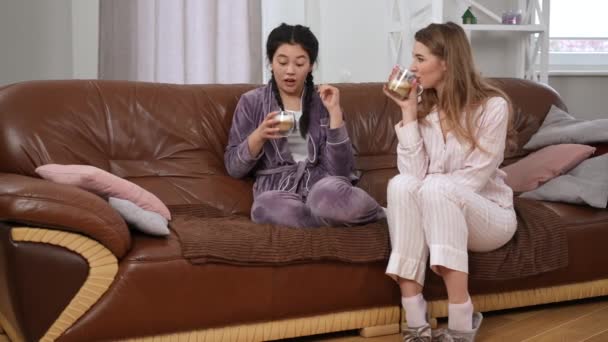Ampla Tiro Relaxado Mulheres Asiáticas Caucasianas Com Cappuccino Sentado Sofá — Vídeo de Stock