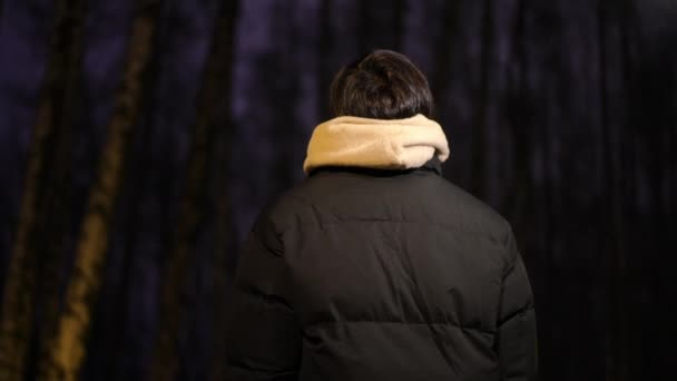 Back View Νεαρός Αγνώριστος Άνδρας Στέκεται Νύχτα Έξω Κοιτάζοντας Γύρω — Αρχείο Βίντεο