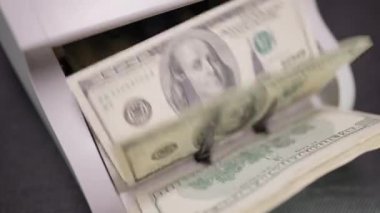 Yüksek açı görüntüsü, nakit 100 doları yavaş çekimde sayıyor. Banknotlar karanlıkta sayma makinesiyle hesaplanıyor. Maliye ve yolsuzluk kavramı