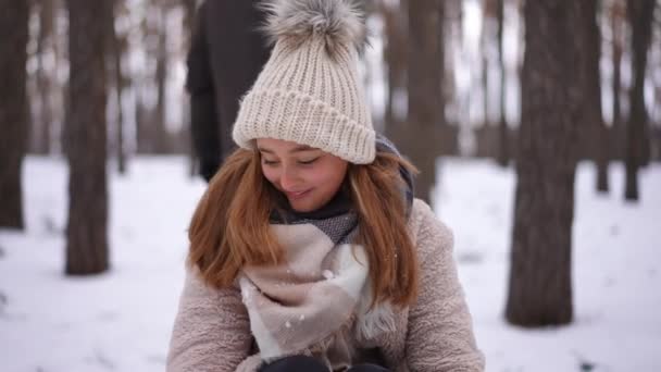 迷人的少女微笑着看着镜头 坐在雪橇上 男孩开始拉着雪橇散步 追踪兴奋的白人青少年在冬天和朋友玩乐时的照片 — 图库视频影像