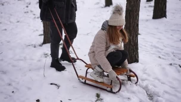 Piękna Nastolatka Siedzi Tyłem Sankach Dotykając Białego Śniegu Jako Nierozpoznawalny — Wideo stockowe