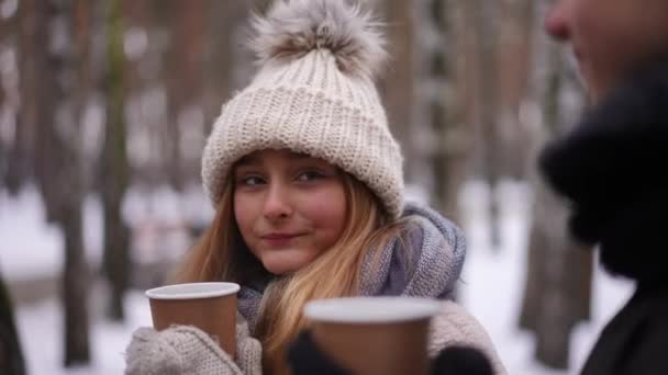 可爱的少女在冬天的公园里喝着热茶和难以辨认的男孩约会 相当自信的白人青少年女友与男朋友共度周末的肖像 慢动作 — 图库视频影像