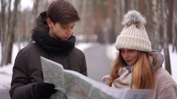 Мальчик Девочка Разговаривают Изучая Бумажную Карту Стоящую Зимнем Парке Портрет — стоковое видео