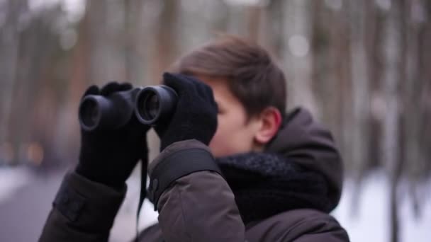 Concentreer Van Verrekijker Tot Nieuwsgierige Tiener Die Rondkijkt Het Winterbos — Stockvideo