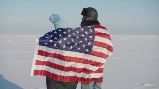 后视镜中的年轻夫妇 肩上挂着美国国旗 在户外欣赏冬天的风景 中枪自信的白种人男人和女人在度假时享受休闲 — 图库视频影像