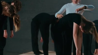 Olgun profesyonel sahne yönetmeni sahne arkasında yetenekli genç aktör ve aktrislerin provalarını yönetiyor. Beyaz kadın, performans bükmeye hazırlanan kadın ve erkeklerle konuşuyor.