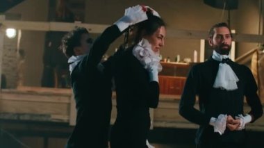 Neşeli tiyatro aktörleri ve aktrisler yaka paça konuşarak gülüyorlar. Pozitif Kafkasyalı yetenekli kadın ve erkek sahne performansına hazırlanırken birbirlerine yardım ediyorlar.