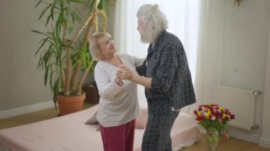 Sevgililer Günü 'nde yatak odasında dans eden mutlu yaşlı çift. Üst düzey Kafkasyalı karı ve koca evde tatilin tadını çıkarıyorlar. Sonsuz aşk kavramı