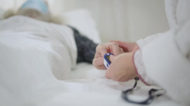 Unrecognizable Woman Measuring Oxygen Saturation Level Ill Man Lying Bed — Vídeo de Stock