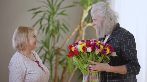 Widok Boku Uśmiechnięty Starszy Mąż Przekazując Bukiet Kwiatów Ukochanej Żonie — Wideo stockowe