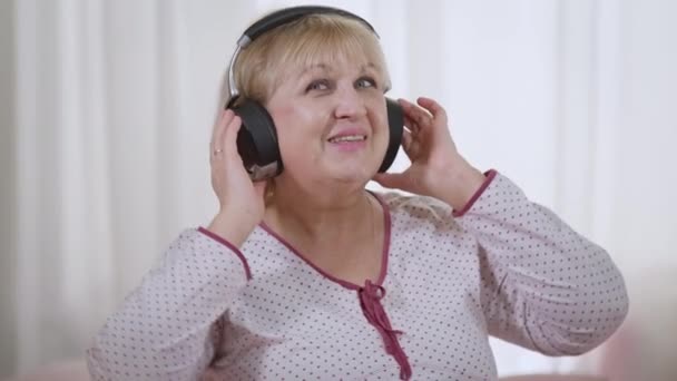 Portrait Carefree Smiling Senior Woman Enjoying Hobby Listening Music Headphones — Vídeo de stock