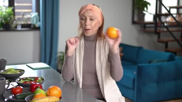 Cheerful Senior Caucasian Woman Juggling Oranges Smiling Sitting Countertop Home — Wideo stockowe