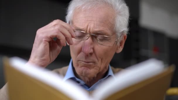 Close Front View Concentrated Senior Man Reading Book Taking Putting — Vídeo de Stock