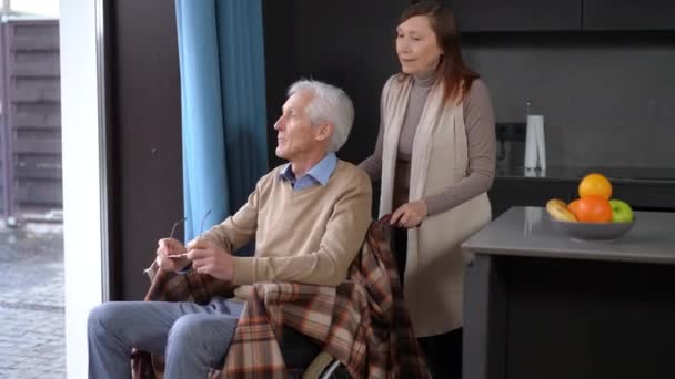 Senior Caucasian Woman Pushing Wheelchair Man Window Talking Smiling Loving — Vídeo de stock