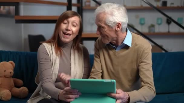 Excited Senior Wife Talking Husband Sitting Digital Tablet Couch Living — Vídeo de Stock