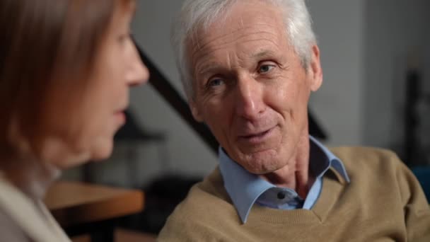 Close Smiling Loving Senior Husband Talking Wife Sitting Living Room — Vídeo de Stock