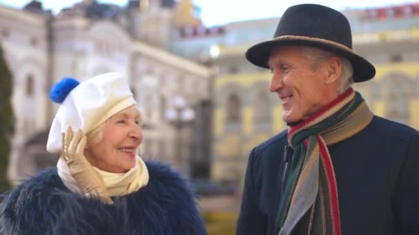 快乐的老年美女和英俊的男人站在城市街道上聊天 一对有信心的白种人退休人员在户外享受休闲的画像 — 图库视频影像