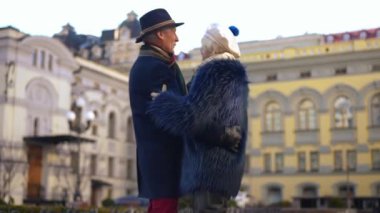 Relaxed confident senior couple dancing on city street talking and smiling. Happy loving Caucasian elegant man and woman enjoying dating outdoors on Valentines Day. Eternal love concept