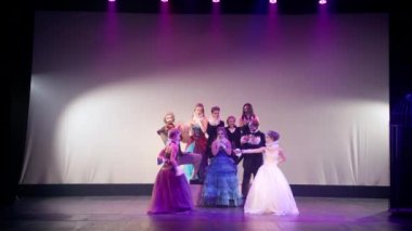 Extreme wide shot of actress throwing back coat as princesses start fighting with swords getting scared running away. Professional theater actors and actresses performing modern fairytale play