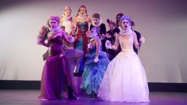 Young talented actresses in gorgeous dresses imitating slow motion fight on stage hitting woman. Caucasian skilled women playing role in theater performing on stage