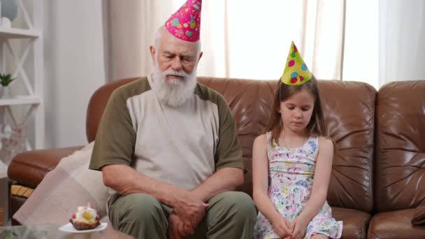 Sad Old Man Sitting Bored Charming Girl Party Hat Couch — Αρχείο Βίντεο