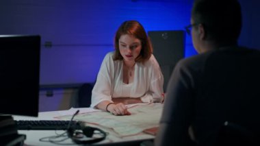 Charming young Caucasian woman laughing out loud talking with man sitting in garage planning startup idea. Joyful millennial startupers thinking discussing project indoors. Creativity and brainstorm